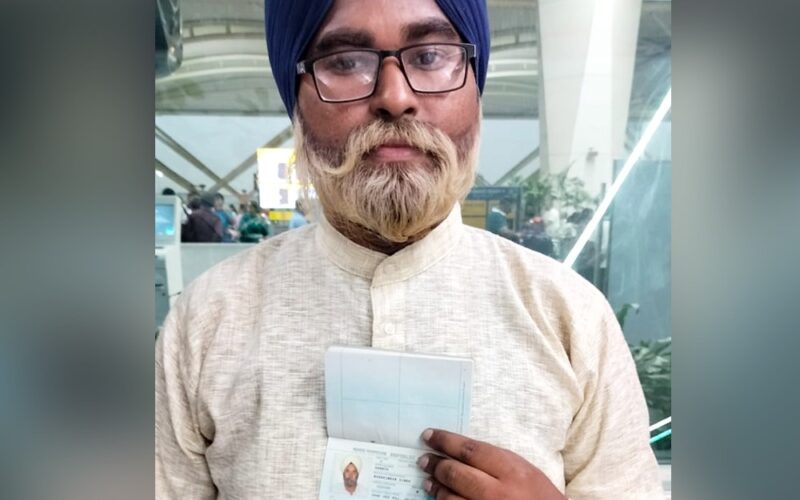 A older-looking man holding a passport.